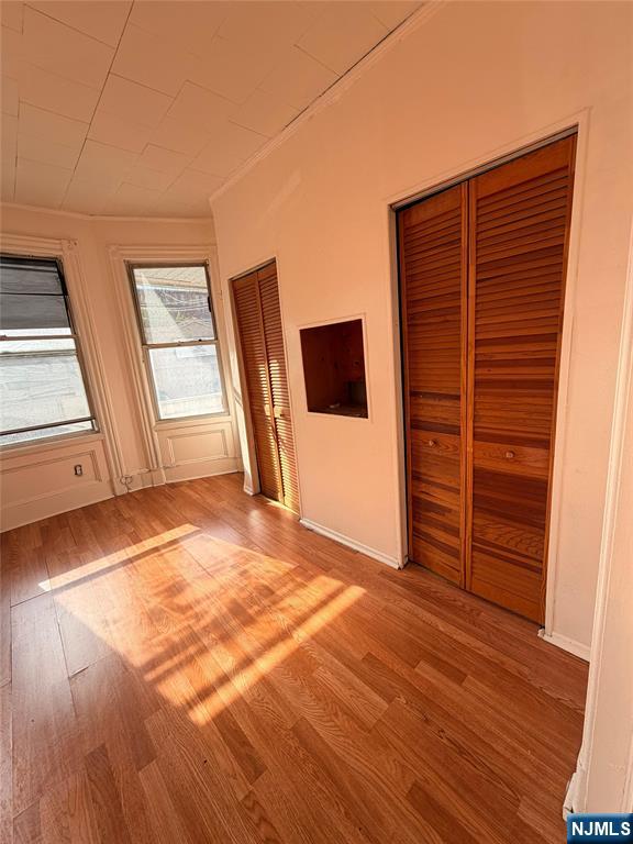 113 Martin Street, Unit 1 Paterson, NJ 07501 - Photo 11 of 14 an empty room with wooden floor and cabinet