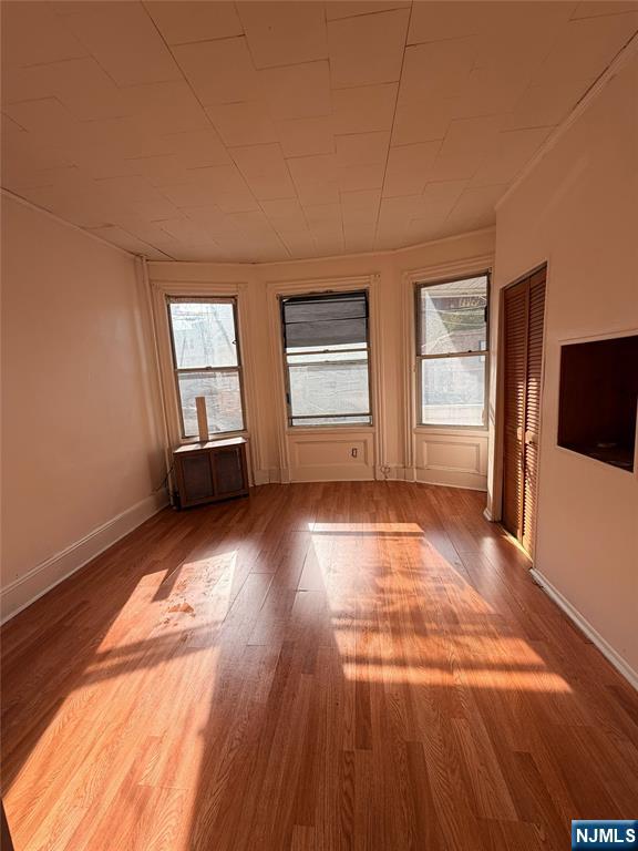 113 Martin Street, Unit 1 Paterson, NJ 07501 - Photo 12 of 14 an empty room with wooden floor and windows