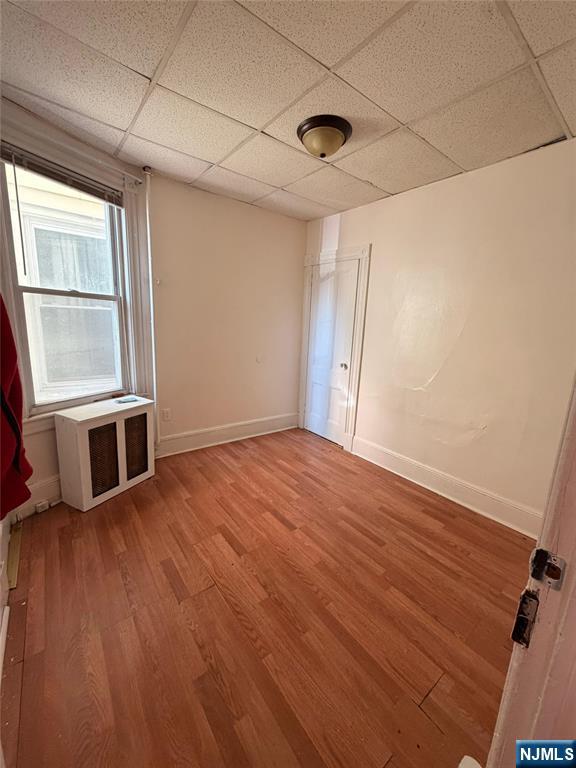 113 Martin Street, Unit 1 Paterson, NJ 07501 - Photo 10 of 14 an empty room with wooden floor and windows