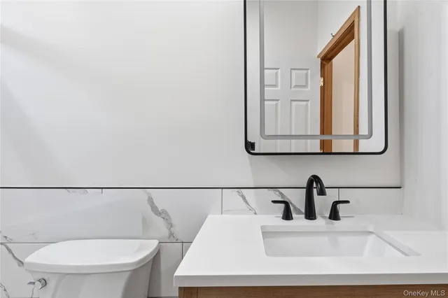a bathroom with a toilet a sink and mirror