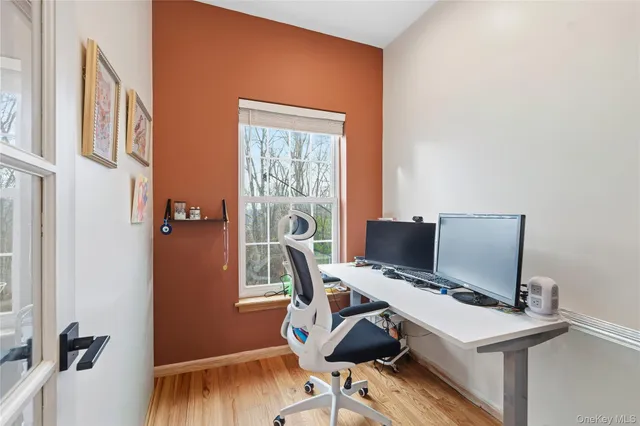 a view of a workspace with furniture and a window
