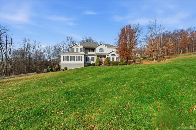 a front view of a house with a yard and trees