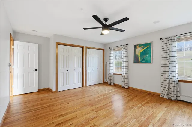 a view of empty room with wooden floor and window