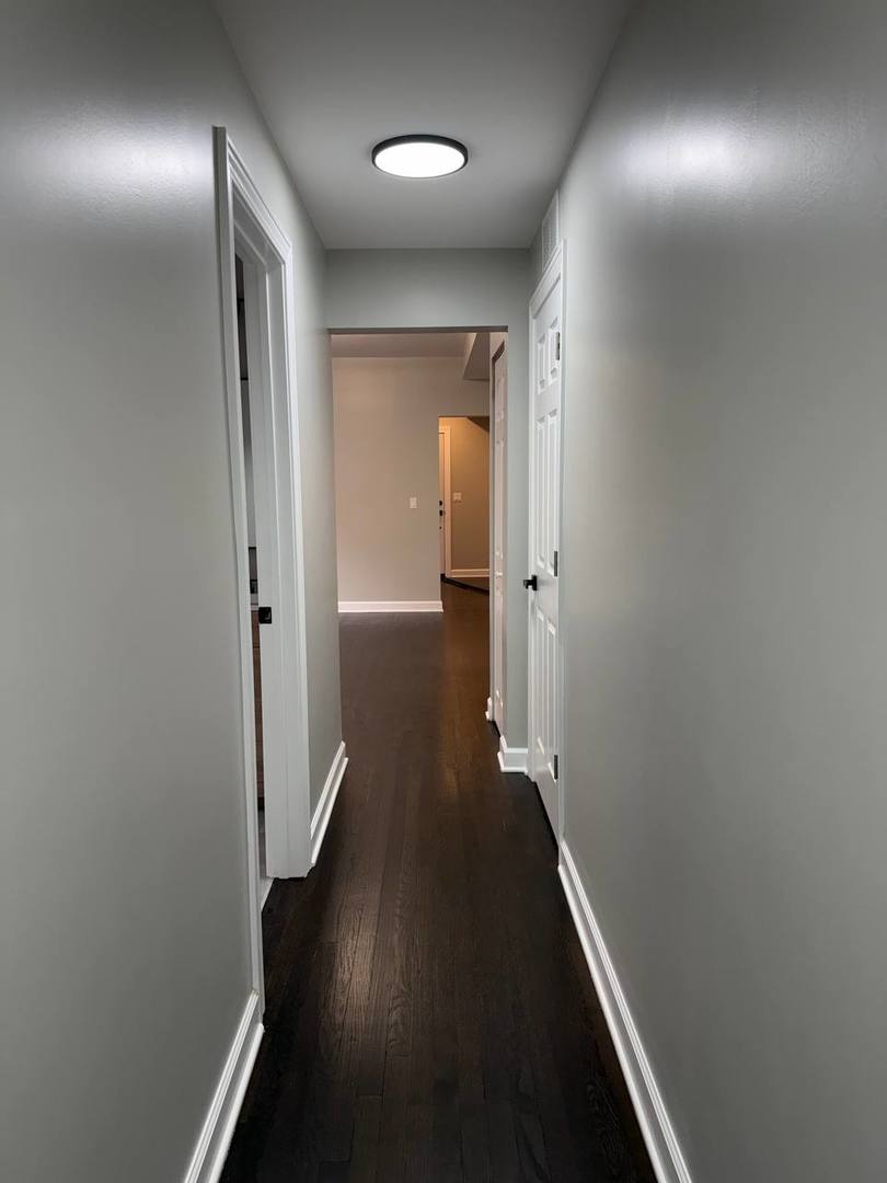 3247 West Thomas Street, Unit 1R Chicago, IL 60651 - Photo 4 of 7 wooden floor in a hall with a mirror