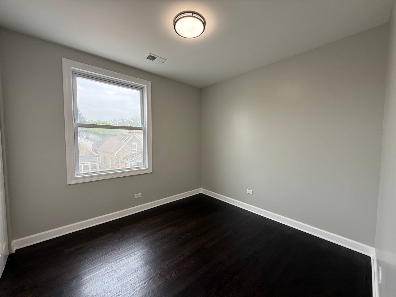 3247 West Thomas Street, Unit 1R Chicago, IL 60651 - Photo 6 of 7 an empty room with wooden floor and windows
