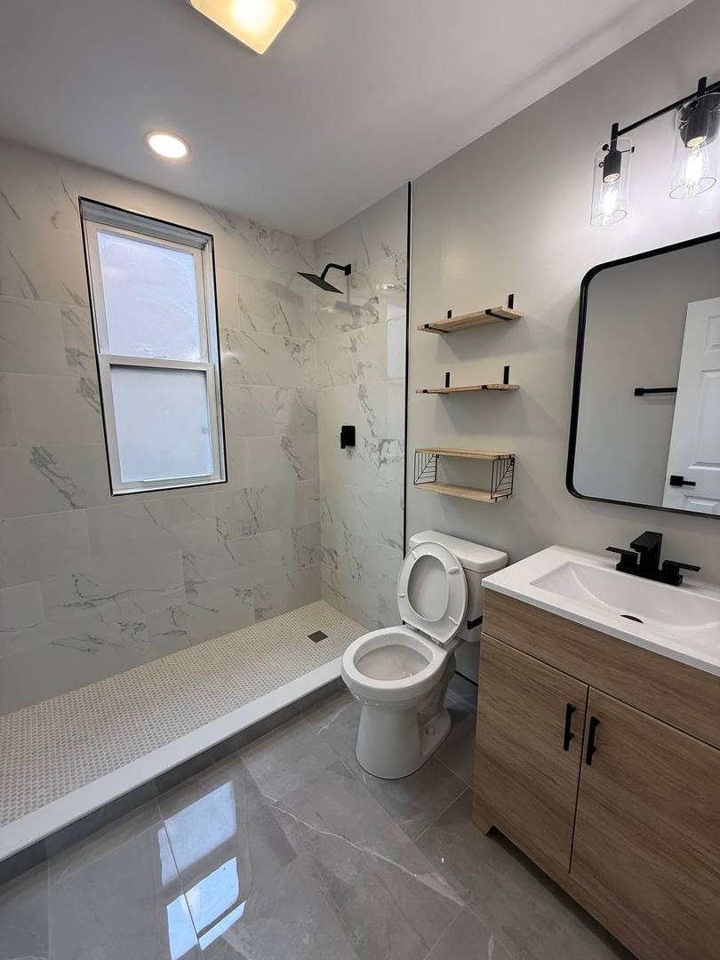 3247 West Thomas Street, Unit 1R Chicago, IL 60651 - Photo 7 of 7 a bathroom with a sink a toilet and shower