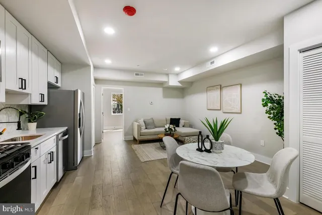 a living room with stainless steel appliances furniture dining table and chairs