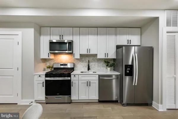 a kitchen with stainless steel appliances granite countertop a stove refrigerator and microwave