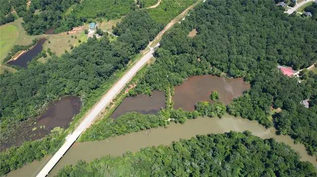 an aerial view of a house with a yard and a lake view