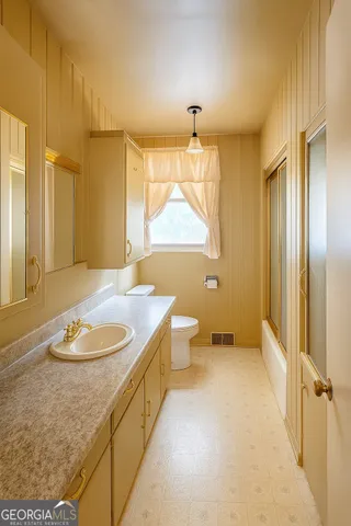 a spacious bathroom with a granite countertop sink a toilet and shower