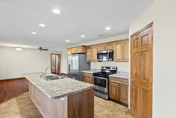 a kitchen with stainless steel appliances granite countertop a sink stove and refrigerator