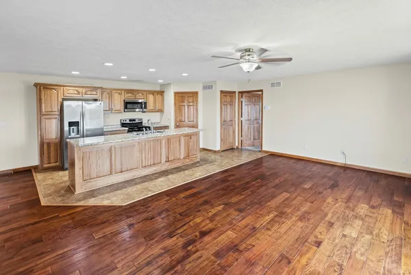 a large kitchen with cabinets wooden floor and stainless steel appliances