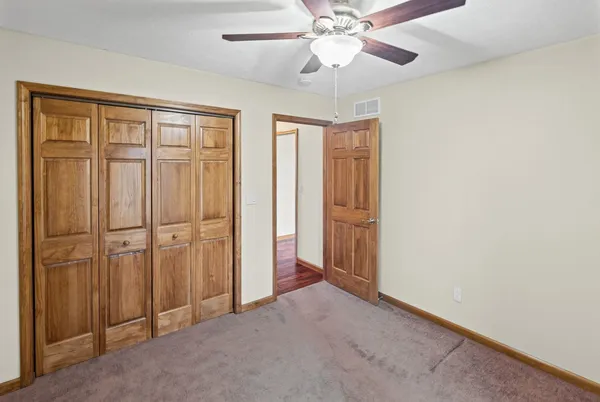 an empty room with chandelier fan