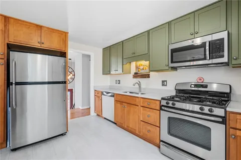 a kitchen with stainless steel appliances granite countertop a refrigerator stove a sink and a microwave