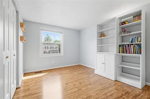a view of empty room with cabinet and closet