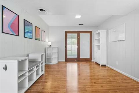 a view of a big room with wooden floor and windows