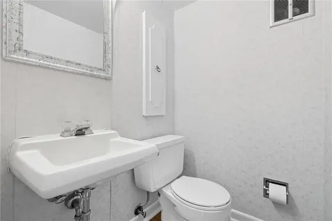 a bathroom with a sink a toilet and mirror