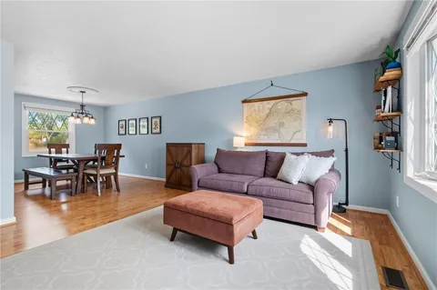 a living room with furniture and a dining table with bookshelf