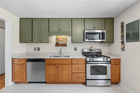 a kitchen with sink a microwave and cabinets