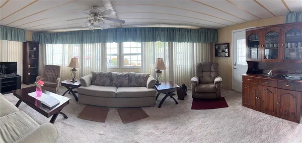 a living room with furniture and a kitchen