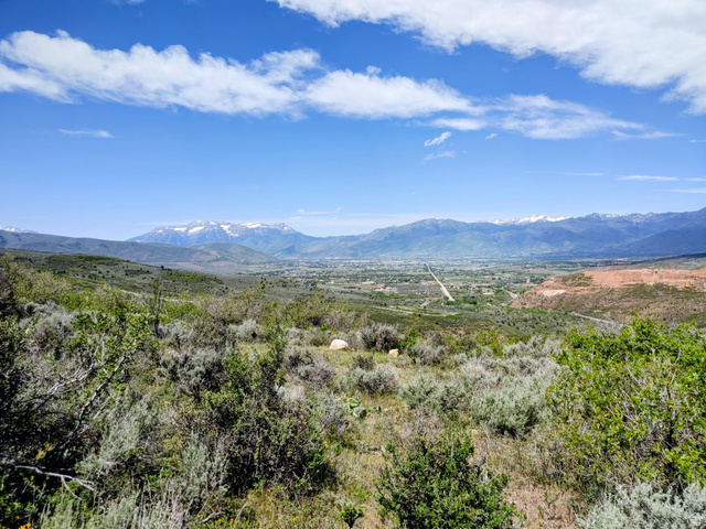 1440 South Beaver Bench Road, Unit 1307 Heber City, UT 84032 - Photo 5 of 7 Expansive natural landscape featuring rolling hills and distant snow-capped mountains under a clear blue sky with scattered clouds