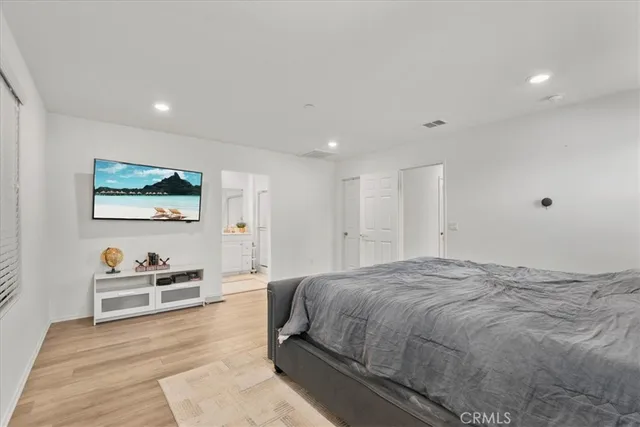 a spacious bedroom with a bed and a painting on the wall