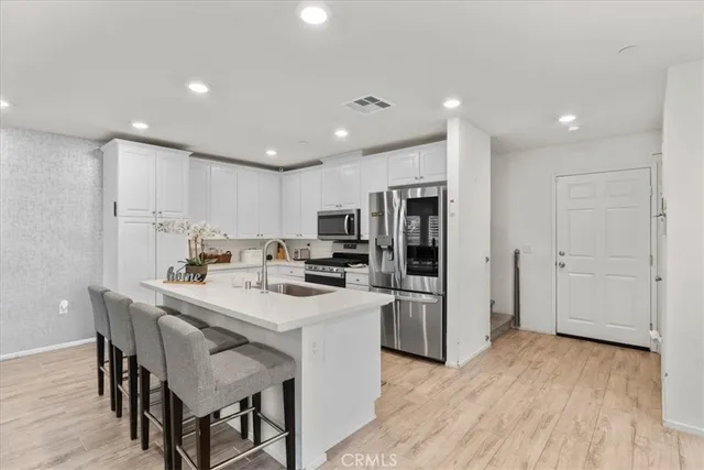 a kitchen with refrigerator and chairs