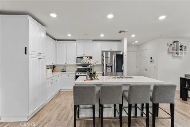 a kitchen with a dining table chairs refrigerator and cabinets