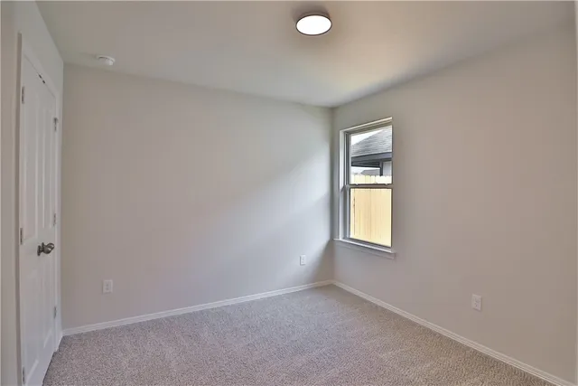 an empty room with windows and mirror