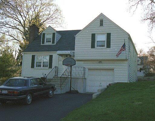 a front view of house with backyard and trees