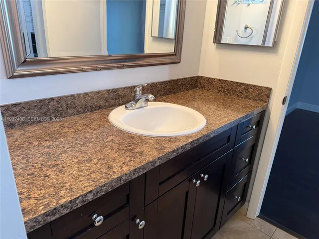a kitchen with granite countertop a refrigerator and a sink