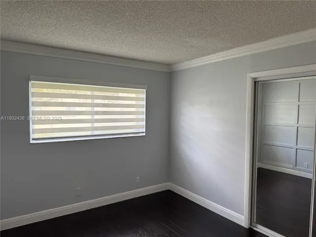 a view of a small space with wooden floor and a window