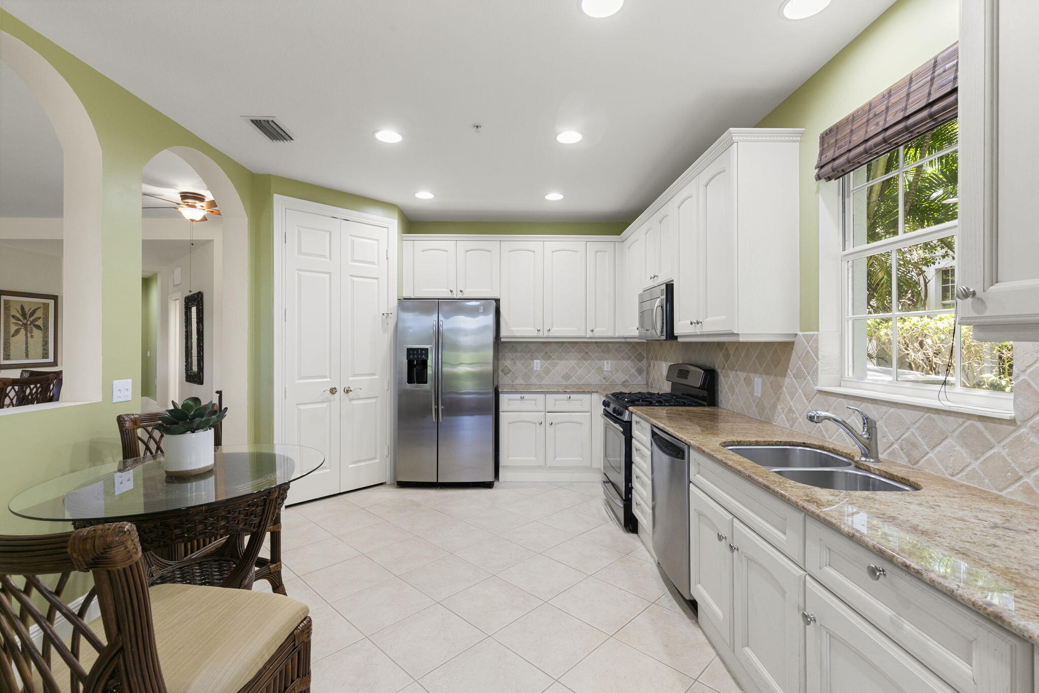 9066 Cascada Way, Unit 101 Naples, FL 34114 - Photo 13 of 51 a kitchen with refrigerator a sink and white cabinets
