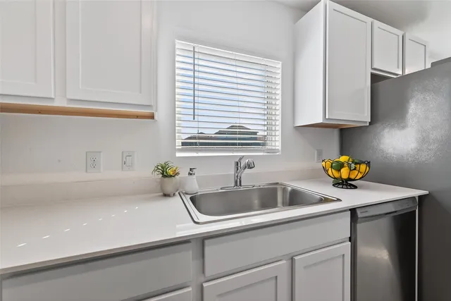 a kitchen with kitchen island white cabinets appliances and a window
