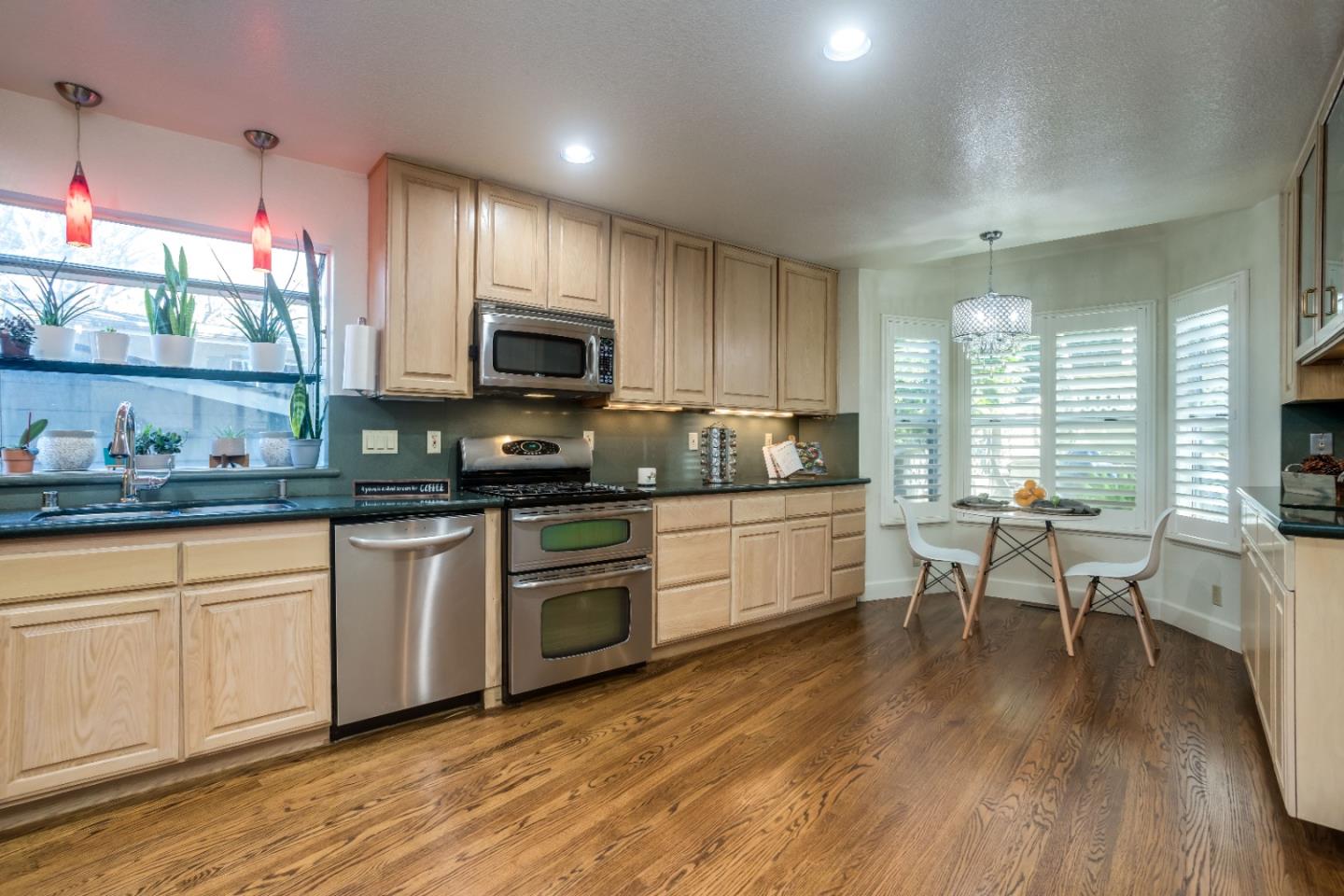 8898 Skyline Boulevard Oakland, CA 94611 - Photo 11 of 35 a kitchen with granite countertop a stove top oven a sink a dining table and chairs
