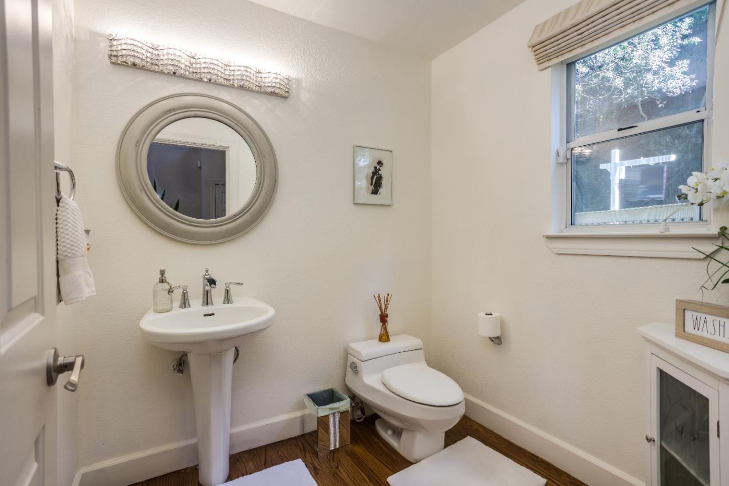 8898 Skyline Boulevard Oakland, CA 94611 - Photo 14 of 35 a bathroom with a sink a toilet and a mirror