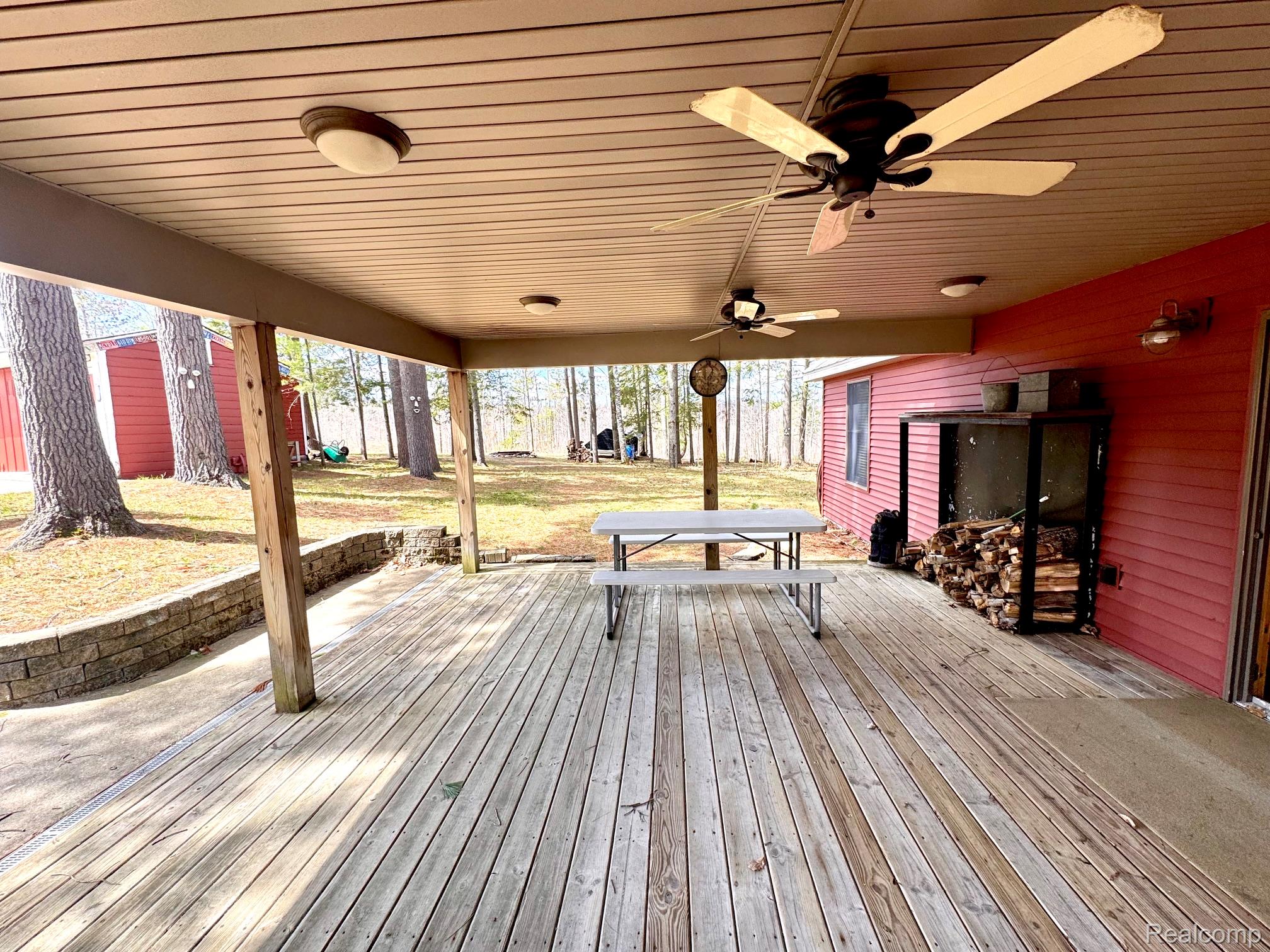 10931 North Roberts Road Frederic, MI 49733 - Photo 5 of 33 Wooden terrace featuring ceiling fan and outdoor dining area