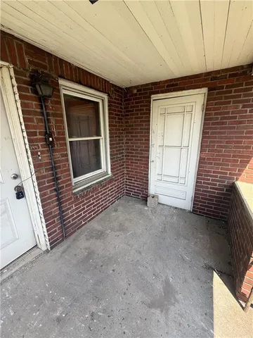 a view of an empty room with a fireplace and a window