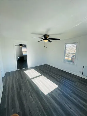 a view of a room with wooden floor and a ceiling fan