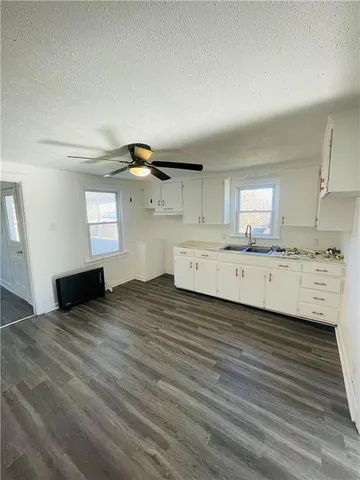 a kitchen with a sink cabinets and wooden floor