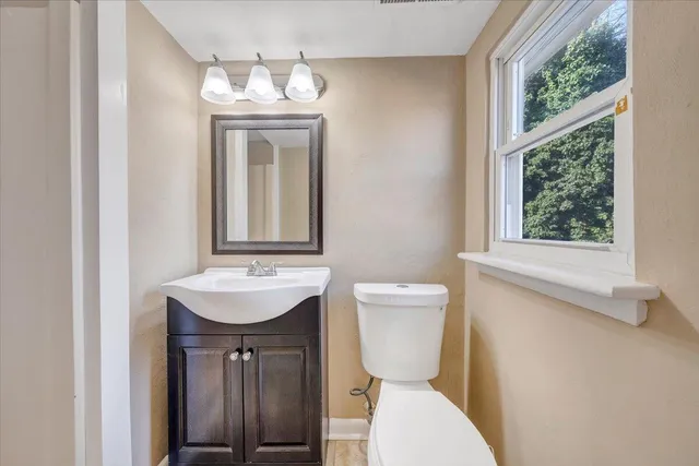 a bathroom with a toilet sink and mirror