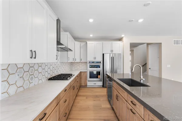 a kitchen with stainless steel appliances granite countertop a sink stove and refrigerator