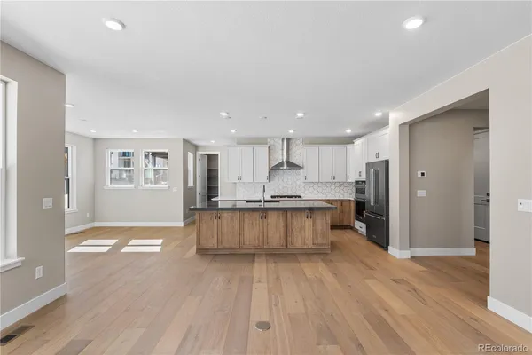 a large kitchen with a lot of counter space and wooden floor