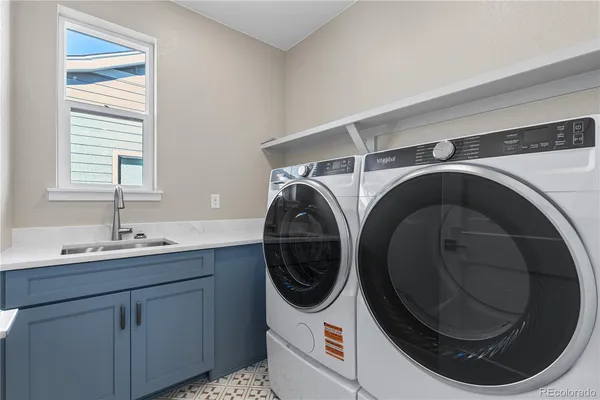 a utility room with sink dryer and washer