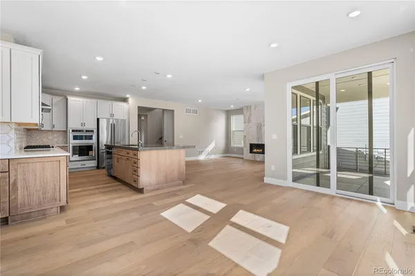a view of kitchen with kitchen island wooden floor center island and stainless steel appliances