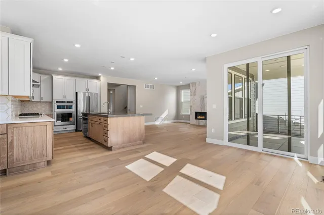 a view of kitchen with kitchen island wooden floor center island and stainless steel appliances