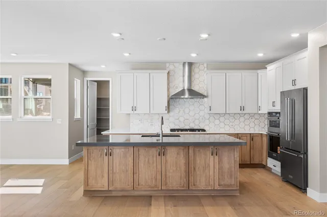 a kitchen with stainless steel appliances granite countertop a stove a sink and a refrigerator