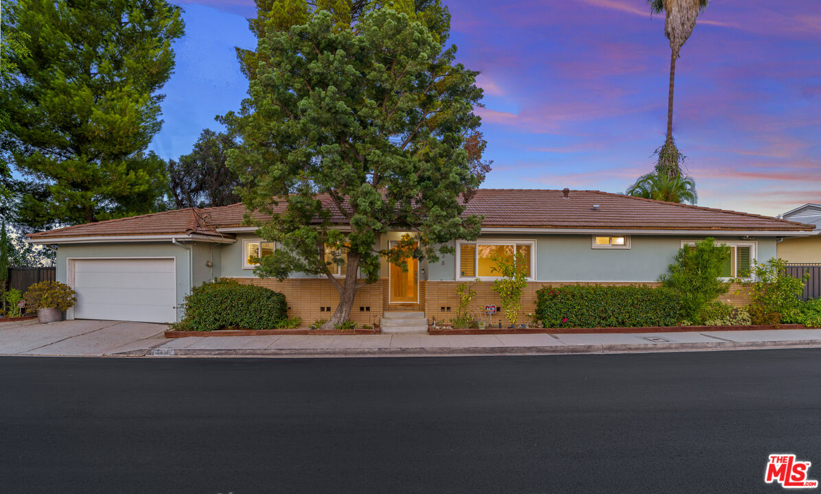2438 Roscomare Road Los Angeles, CA 90077 - Photo 1 of 17 a front view of a house with garden