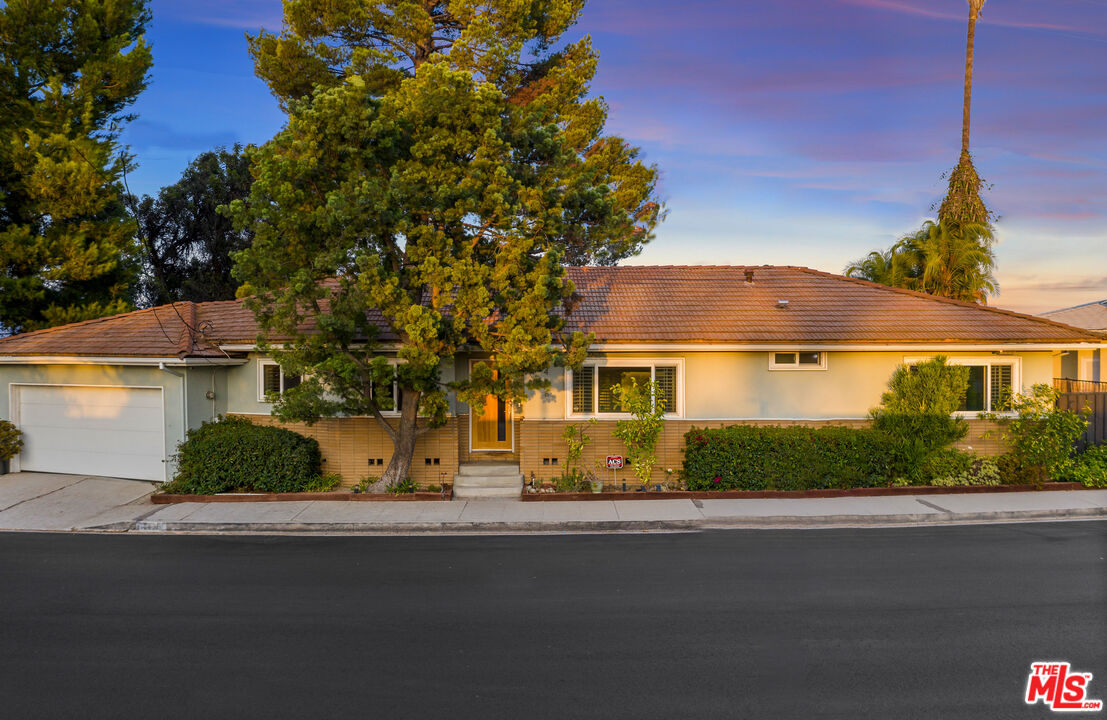 2438 Roscomare Road Los Angeles, CA 90077 - Photo 2 of 17 a front view of a house with a garden