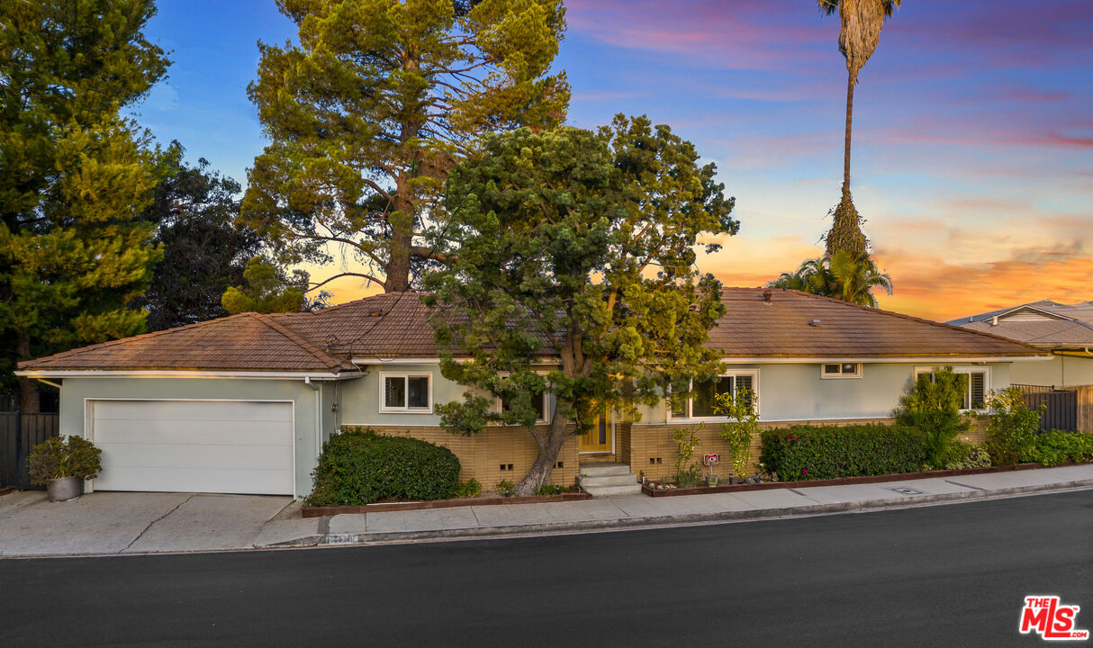2438 Roscomare Road Los Angeles, CA 90077 - Photo 4 of 17 a front view of a house with a garden and tree